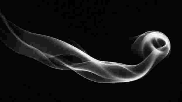 Artistic black and white photo of a smooth smoke curve on a dark background.