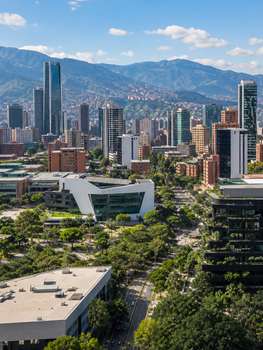 Bright day cityscape of Medellín, Colombia featuring modern architecture and green spaces.