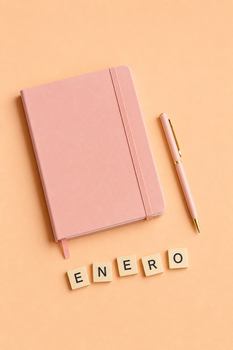Minimalist flat lay of a pink notebook, pen, and ENERO tiles on a peach background.