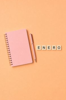 Minimalist flat lay of a pink notebook, pen, and ENERO tiles on a peach background.