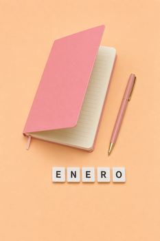 Minimalist flat lay of a pink notebook, pen, and ENERO tiles on a peach background.