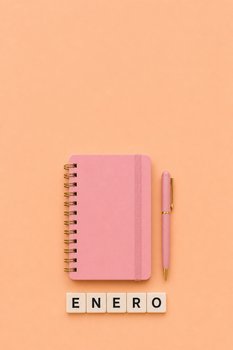 Minimalist flat lay of a pink notebook, pen, and ENERO tiles on a peach background.