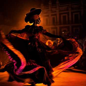 Silhouette of a Catrina dancer with vibrant light trails in a dark setting, embodying Mexican culture.